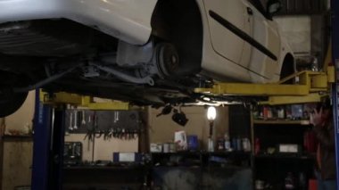 Servis istasyonu atölyesinde asansörde arka tekerlek olmadan bir araba kaldırma