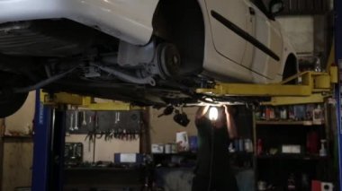 Servis istasyonu atölyesinde asansörde arka tekerlek olmadan bir araba kaldırma