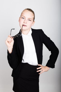 Gözlüklü küçük iş kadını yeni bir fikir düşündü. İş tarzında çocuk kız Stüdyo portresi.