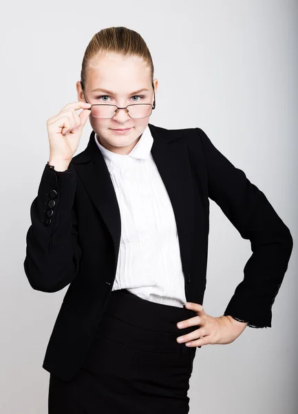 Eine kleine Geschäftsfrau mit Brille dachte sich eine neue Idee aus. Studioporträt eines Mädchens im Business-Stil. — Stockfoto