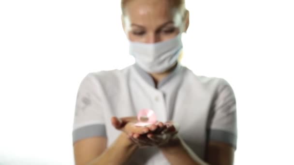 Close-up of female doctor hands holding pink ribbon. breast cancer awareness. healthcare and medicine concept — Stock Video