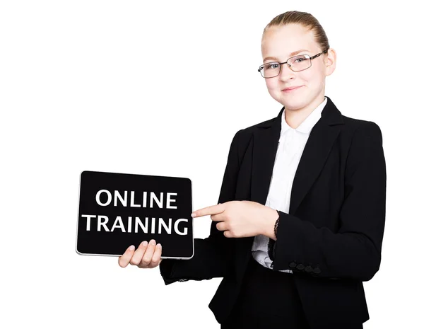 Mooie schoolmeisje in een Business Suit houdt een PC Tablet in zijn handen en op zoek naar de camera, op een PC Tablet inscriptie online training — Stockfoto