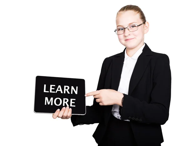 Schoolmeisje in een Business Suit houdt een PC Tablet in zijn handen en op zoek naar de camera, op een PC Tablet inscriptie meer informatie — Stockfoto