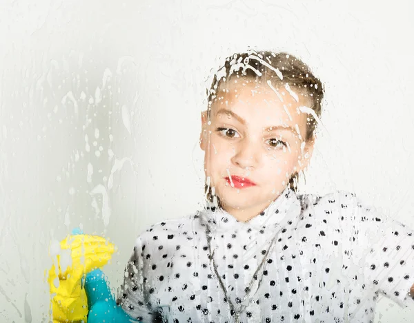 A dona de casa sorridente lavou a janela com um pano e detergente. Vidro grande em espuma. Conceito de trabalho doméstico . — Fotografia de Stock