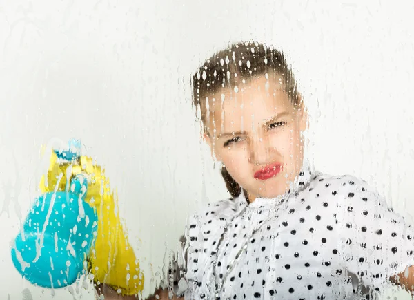 A dona de casa sorridente lavou a janela com um pano e detergente. Vidro grande em espuma. Conceito de trabalho doméstico . — Fotografia de Stock