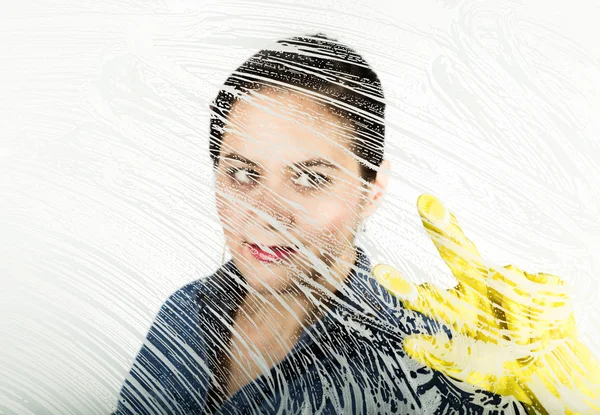 Junge Hausfrau gewaschen Fenster mit einem Spray, Tuch und Spülmittel. großes Glas in Schaumstoff. Hausaufgabenkonzept. — Stockfoto
