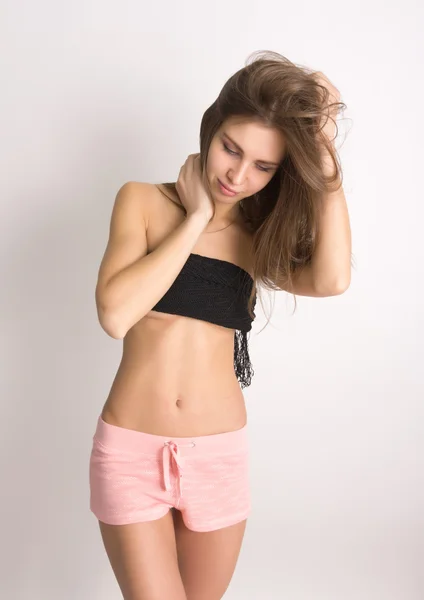 Wanita muda seksi mengenakan celana pendek merah muda — Stok Foto