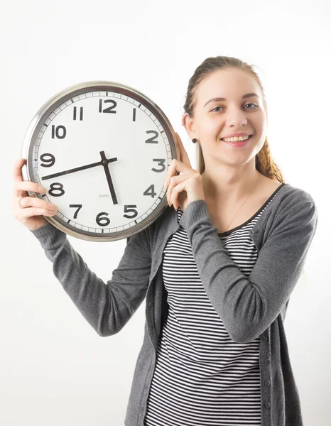 Beautiful young woman looking at a large silver retro clock that she is holding, she wonders how much time passed — ストック写真