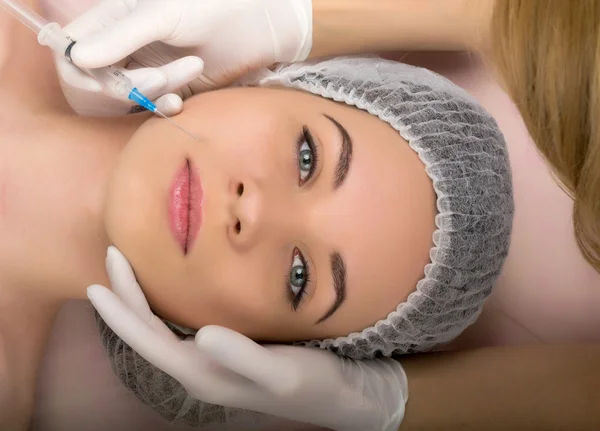 Kozmetikus megvizsgálja az arcát egy fiatal női ügyfél a spa szalon. kozmetikus szépség injekciót. Szakmai konzultáció. — Stock Fotó