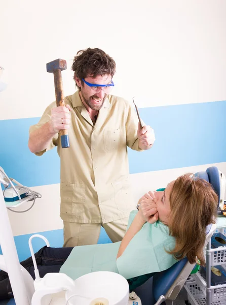 El dentista loco trata los dientes del paciente desafortunado. El paciente está aterrorizado. . — Foto de Stock