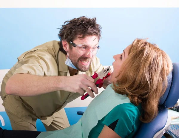 Verrückter Zahnarzt behandelt Zähne unglücklicher Patientin — Stockfoto