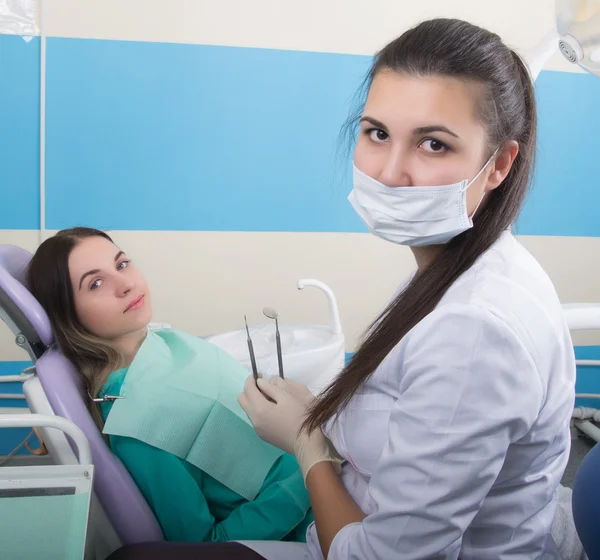 Genç kadın dişçi klinikte ziyaret dişçi. Doktor diş çürüğü sözlü den inceliyor. — Stok fotoğraf