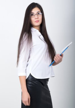 Beyaz bir bluz, siyah deri etek ve gözlük bir klasör belgeler ile tutan genç çok zayıf Asyalı kadın