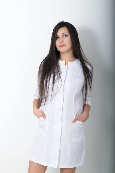 Красивая молодая азиатка-врач в медицинском халате держит фонендоскоп — стоковое фото