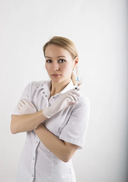 Bella giovane medico donna in abito medico e guanti di gomma che tengono una siringa. infermiera — Foto Stock