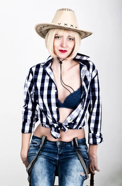 Young beautiful sexy woman in a plaid shirt jeans and a cowboy hat — 图库照片