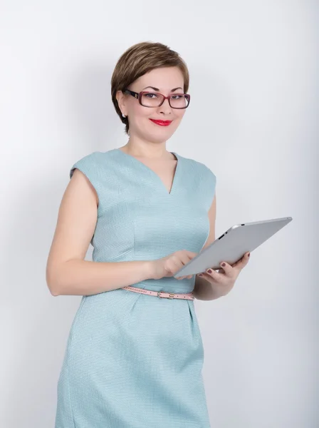 Schöne asiatische Frau in einem Business-Anzug und Brille hält ein Tablet in den Händen von — Stockfoto