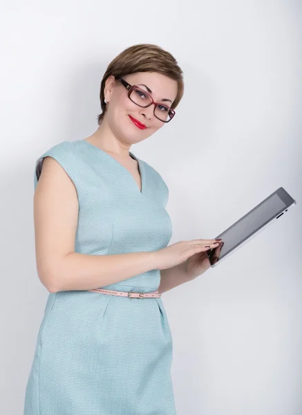 Beautiful asian woman in a business suit and glasses holds a tablet in the hands of — Stock Photo, Image