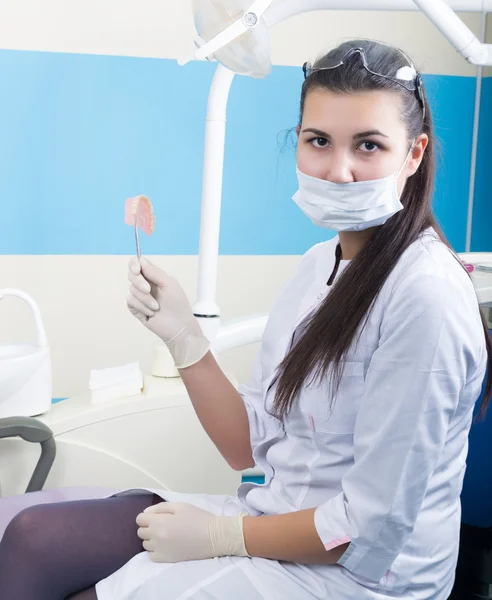 Красива азіатська молода жінка стоматолог тримає зубні протези — стокове фото