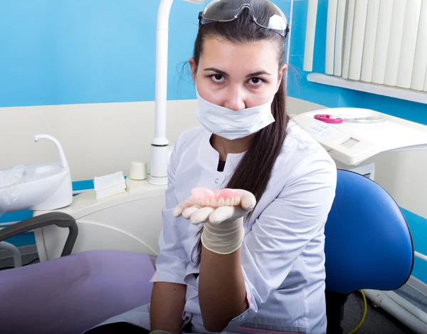 Hermosa asiático joven mujer dentista holding dentaduras postizas — Foto de Stock