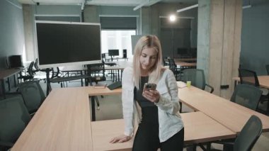 İş dünyası modern ofis ortamında akıllı telefonlar kullanırken belgelerle işbirliği yapıyor