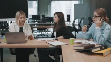 Çalışma saatlerinde belge ve teknolojiyle modern ofiste takım tartışmaları