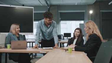 İş toplantısı, çalışma arkadaşları arasındaki parlak ofis ortamında yavaş çekim ekibinin etkileşimini yakaladı