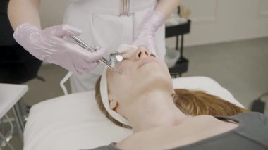 Sakin bir güzellik salonundaki bir kadın için yavaş çekim kalıcı makyaj uygulaması