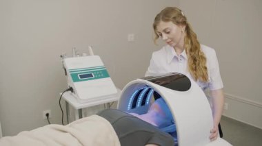 Yavaş çekimde güzellik tedavisi, samimi bir salondaki müşteriye kalıcı makyaj uygulaması sunar