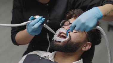 Tedavi sırasında bir hastayla modern bir klinikte diş temizleme prosedürü