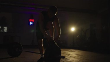 Ağır çekimde yapılan dayanıklılık eğitimi, gece spor salonunda odaklanmayı ve kararlılığı vurguluyor.