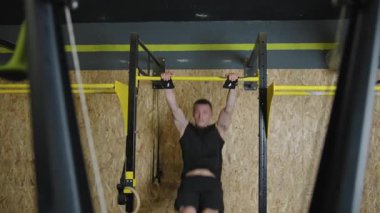 Güçlü adam spor salonunda kas gücünü ve azmini yavaş çekimde sergiliyor.