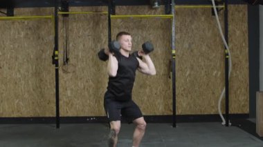 Spor salonunda barfiks çeken bir adam.