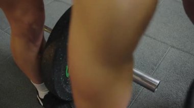 Kadınlar antrenman sırasında ağırlık kaldırıyor. Güç antrenmanı ve fiziksel kondisyona odaklanıyor.