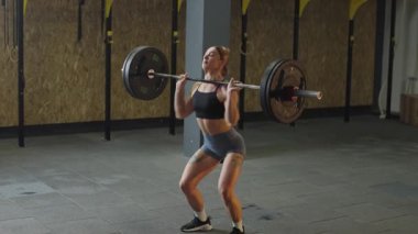 Kadınlar antrenman sırasında ağırlık kaldırıyor. Güç antrenmanı ve fitness üzerine odaklanıyor.