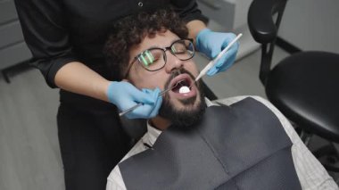 Adam rutin randevusu sırasında klinikteki dişçiden diş muayenesi alıyor.