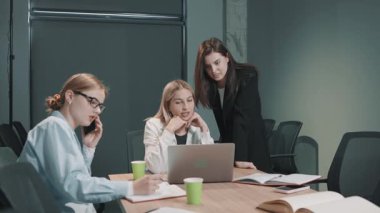 Takım toplantısı sırasında sorunları çözmek ve fikirleri tartışmak için ofis ortamında iş birliği yaparlar