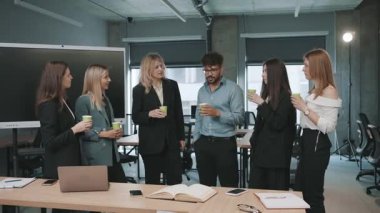 Meslektaşlar ofis alanındaki bir takım toplantısında proje ve fikirleri tartışırlar.