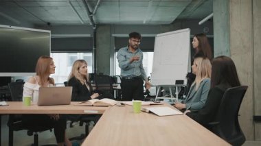 Ofiste yapılan ekip toplantısında çalışma saatlerinde iş arkadaşları arasında proje güncellemeleri ve işbirliği üzerinde duruluyor