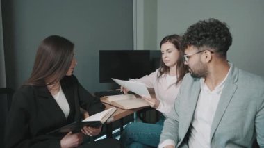 Ofiste iş arkadaşlarıyla fikir alışverişinde bulunmak ve bir toplantıda notlar almak.