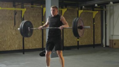 Sporcu halterini kaldırarak yarışma hazırlığı için spor salonunda güçlü bir antrenman.