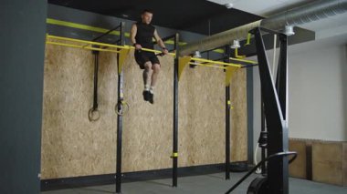 Sporcu öğleden sonra spor salonundaki spor yüzüklerinde güç antrenmanı yapıyor.