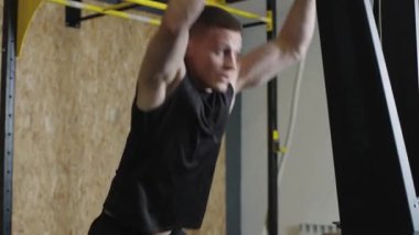 Spor salonundaki spor salonunda barfiks çekmek için antrenman yapan sporcu.