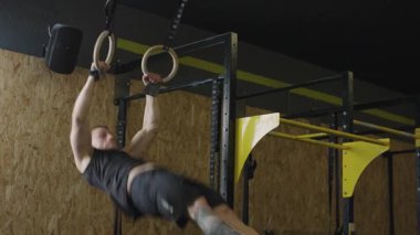 Spor salonunda güç ve spor için jimnastik yüzükleri eğitimi alıyorum.