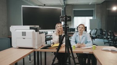 Bir ofis ortamında kamera kaydıyla proje planlarını tartışan kadın ve erkek ile iş görüşmesi.