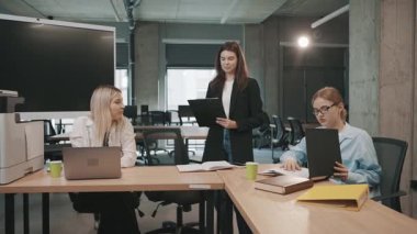 Ekip üyeleri şehirdeki bir iş toplantısında projeleri parlak bir ofiste tartışırlar.