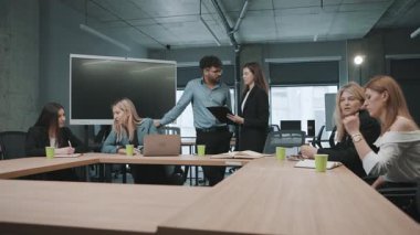 Gündüzleri modern ofis ortamında proje fikirlerini tartışan erkek ve kadınlarla iş toplantısı.