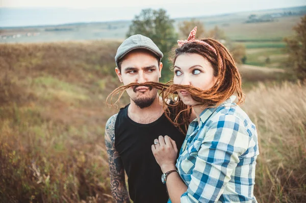 Erkek ve kız, dreadlocks ile oynarken birbirlerine bıyık yapmak — Stok fotoğraf