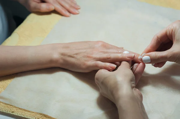 Unhas revestimento transparente é um close-up no salão de beleza. Processo de manicure . — Fotografia de Stock