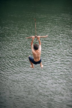 genç adam bir ip ile nehre atlama